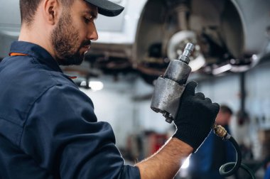 Elimde özel bir alet var. Araba tamirhanesinde çalışan bir tamirci..