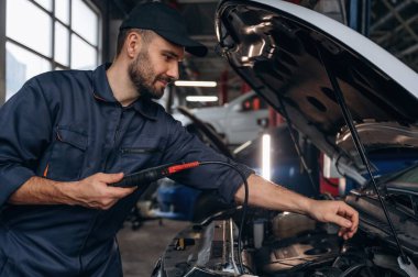 Dijital tablet bağlanıyor. Araba tamirhanesinde çalışan bir tamirci..