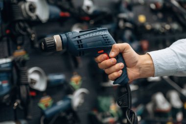 Perforatör matkabı. Hırdavatçıda adamın elinin detaylı yakın görüntüsü..