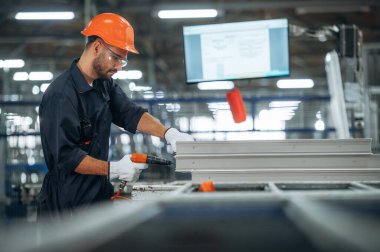 Tornavida kullanıyorum. İnsanlar modern fabrikada çalışıyor..