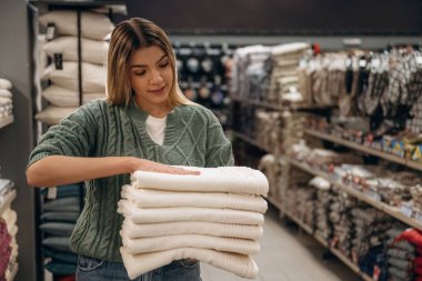 Temiz havluları alıyorum. Kadın hırdavatçı dükkanında, alışveriş konsepti..