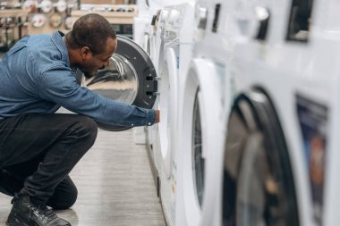 Çamaşır makinesiyle. Ev gereçleri dükkanındaki adam..