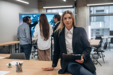 Kadının ön görüntüsü. Bir grup ofis çalışanı içeride birlikte..