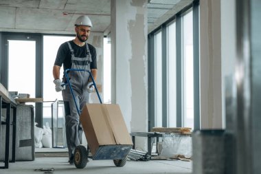 Eşyaları taşıyorum. Bir adam bitmemiş bir odayı yeniliyor..