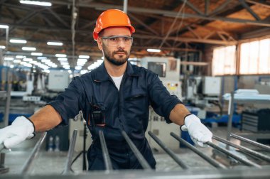 Profesyonel tamirci ya da teknisyen, ayakta duruyor. İnsanlar modern fabrikada çalışıyor..