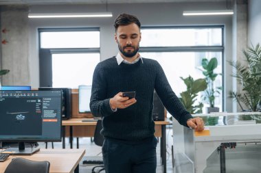 Akıllı telefon elindeydi. İnsan modern ofiste, tek kişidir..