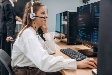 Bilgisayarların başında oturuyor. Tasarımcı takımı ofiste birlikte..