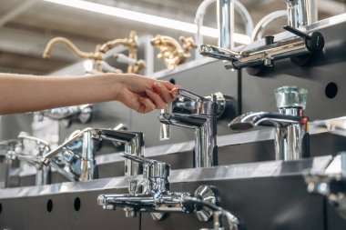 Banyo musluğu. Hırdavatçıdaki kadının yakın görüntüsü..