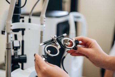 Göz doktoru gözlüğü tutan kadın doktorların ellerine yakından bakın..