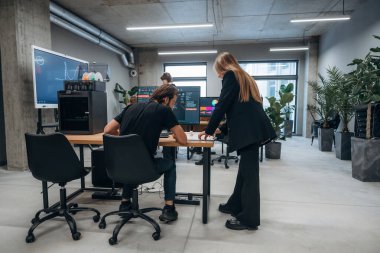 3d yazıcı yazılımı ile göster. Tasarımcı takımı ofiste birlikte..