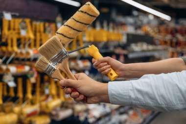 Boya fırçalarıyla. Hırdavatçıdaki kadın ve erkeğin ellerinin detaylı görüntüsü..