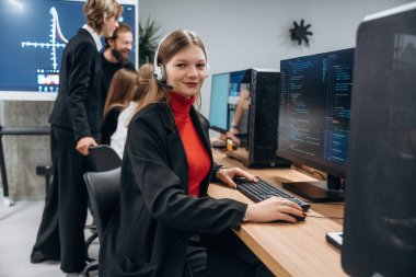 Bilgisayarların başında oturuyor. Tasarımcı takımı ofiste birlikte..