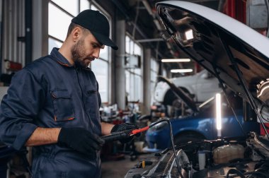 Yandan bak, kaputu aç. Araba tamirhanesinde çalışan bir tamirci..