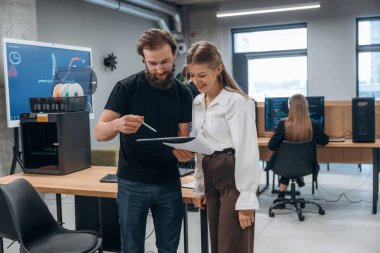 Erkek ve kadın ayakta duruyor. Tasarımcı takımı ofiste birlikte..