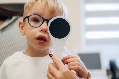 Gözü kapatıyorum. Küçük çocuk göz doktorunun dolabını kontrol ediyor..