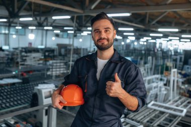 Başparmağımı gösteriyorum. İnsanlar modern fabrikada çalışıyor..