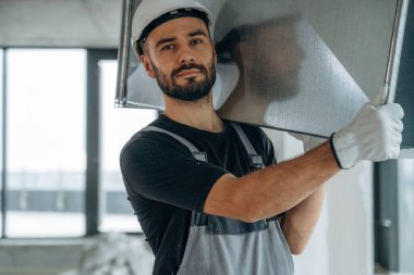 Eşyaları taşıyorum. Bir adam bitmemiş bir odayı yeniliyor..