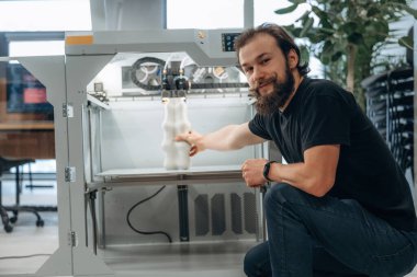 Ürün hazır. Adam 3D yazıcıyla ofiste..