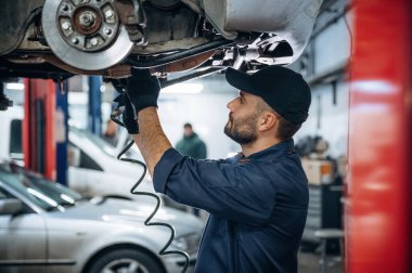 Profesyonel ekipmanlar. Araba tamirhanesinde çalışan bir tamirci..