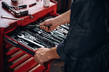 Bir sürü aleti olan bir masa. Araç servis istasyonundaki tamircinin görüntüsünü kapat.