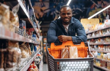 Gülümseyen, pozitif yüz ifadesi. Erkek müşteri süpermarkette..