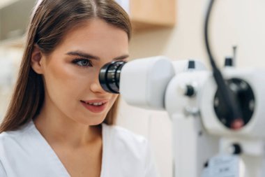 Dijital optik cihaz. Genç bayan göz doktoru kabinede..