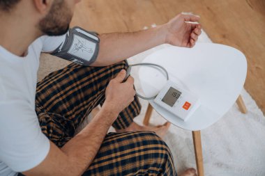 İnsan oturuyor ve kan basıncını ölçüyor..