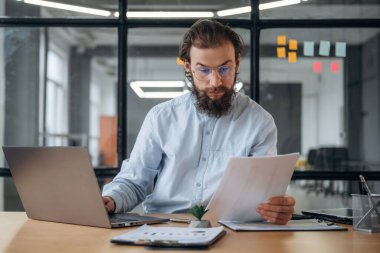 Belgeyi okuyorum. İşadamı ofiste çalışıyor..