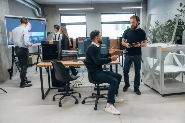 İşbirliği ve iletişim kavramı. Ofiste 3D yazıcının yanında insanlar var..