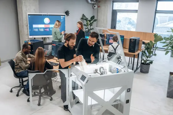 Modern teknoloji. Ayakta. Ofiste 3D yazıcının yanında insanlar var..