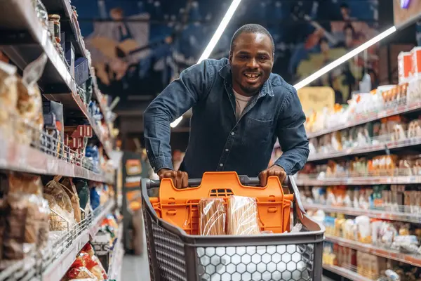 Gülümseyen, pozitif yüz ifadesi. Erkek müşteri süpermarkette..