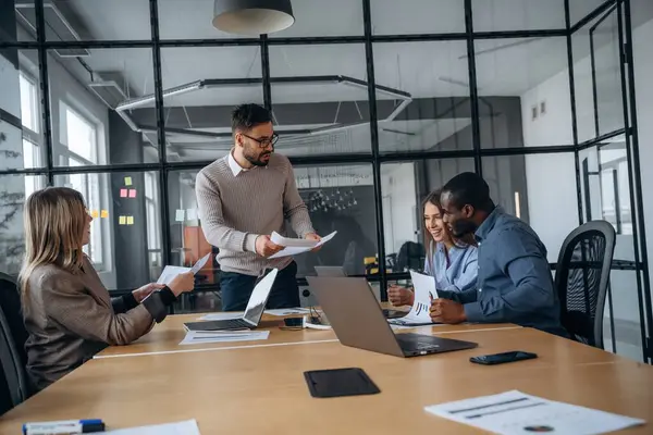 Masanın yanında. Profesyonel işçiler modern ofiste birlikte çalışıyorlar..