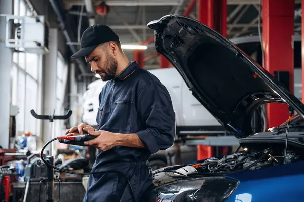 Elektronik ayarlama, dijital tabletle. Araba tamirhanesinde çalışan bir tamirci..