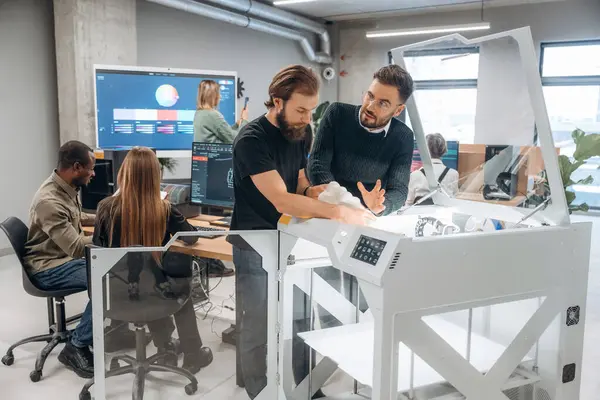 Modern teknoloji. Ayakta. Ofiste 3D yazıcının yanında insanlar var..