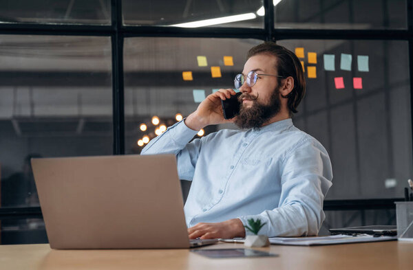 Talking by phone. Businessman is working in the office.