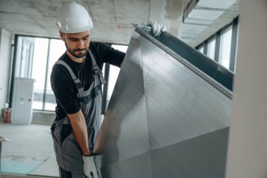 Eşyaları taşıyorum. Bir adam bitmemiş bir odayı yeniliyor..