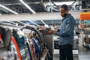 Elektrikli süpürge. Ev gereçleri dükkanındaki adam..