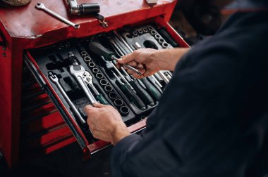 Bir sürü aleti olan bir masa. Araç servis istasyonundaki tamircinin görüntüsünü kapat.