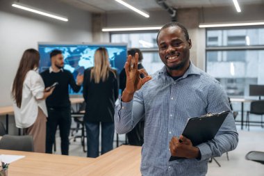 Siyah adam not defteriyle birlikte. Bir grup ofis çalışanı içeride birlikte..
