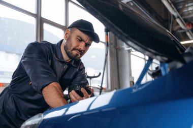 İşine odaklan. Tamirci bir araba istasyonunda..