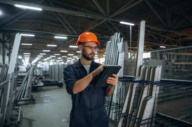 Dijital tabletle. İnsanlar modern fabrikada çalışıyor..