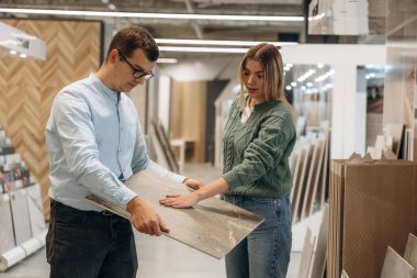 Parke seçmeme yardım ediyor. Erkek ve kadın hırdavatçıdalar..