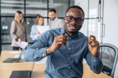 Pozitif siyah adam. Profesyonel işçiler modern ofiste birlikte çalışıyorlar..