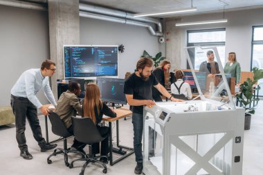 Ofiste 3D yazıcının yanında insanlar var..