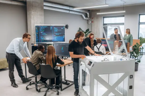 Ofiste 3D yazıcının yanında insanlar var..