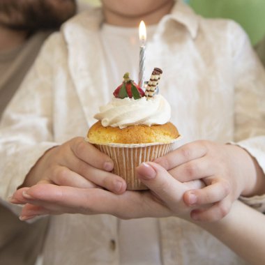 Elinde mum olan doğum günü keki seçici bir odak noktası