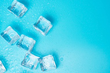 Su damlaları arkaplanı kopyalama alanı olan mavi üzerine buz küpleri