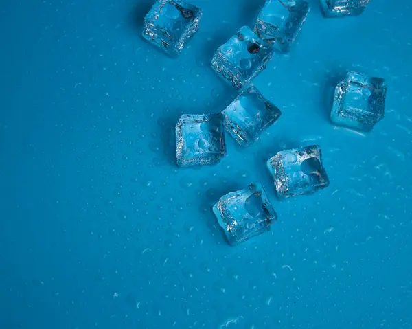 Кубики Льоду Краплями Води Розкиданими Синьому Фоні Вид Зверху — стокове фото