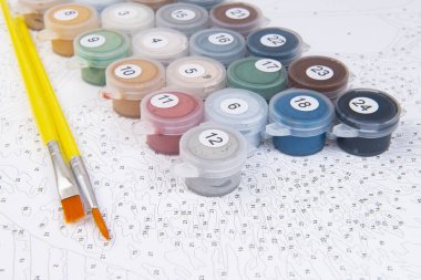 Beyaz arka planda renkli boya ve fırçalarla çocuk çizimleri öğretiyorlar.