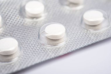 Beyaz hapların makro görüntüsü arka arkaya izole edilmiş.